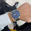 Stilfuld mand bærer Armani kvarts herreur model AR 11362 med blå skive og tofarvet stållænke, perfekt tilbehør for ure til mænd